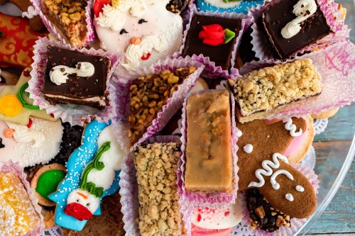 A colorful assortment of festive pastries and cookies, including chocolate treats, decorated sweets, and gingerbread.