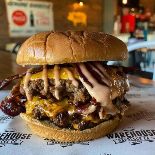 A juicy burger with melted cheese, bacon, and sauce, served on a toasted bun at Warehouse Barbecue Co.