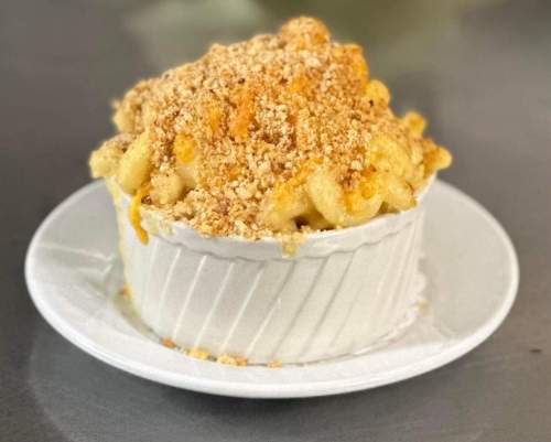 A creamy macaroni and cheese dish topped with a golden breadcrumb crust, served in a white ramekin.