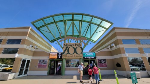 Entrance to Mesker Park Zoo & Botanic Garden, featuring a large sign and a modern, green roof structure.
