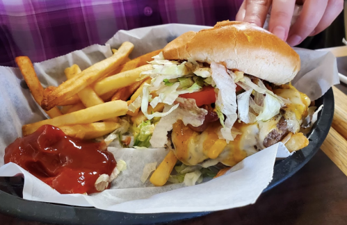 A juicy cheeseburger topped with lettuce and tomato, served with fries and ketchup on the side.