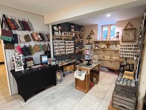 A cozy shop interior displaying handmade crafts, jewelry, and accessories on shelves and tables.