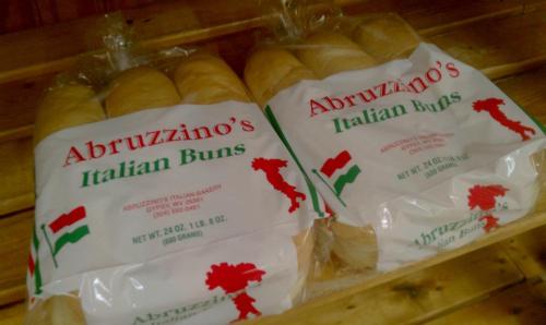 Two packages of Abruzzino's Italian buns, each weighing 24 oz, displayed on a wooden surface.