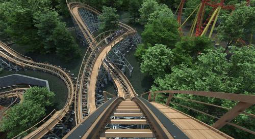 Aerial view of a wooden roller coaster winding through a lush green forest.