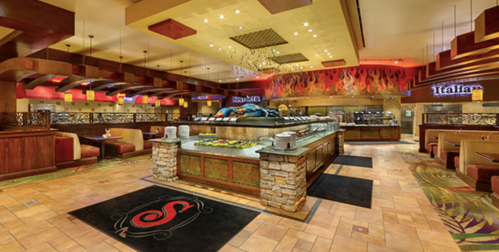 Interior of a buffet restaurant featuring colorful decor, a food display area, and cozy seating arrangements.
