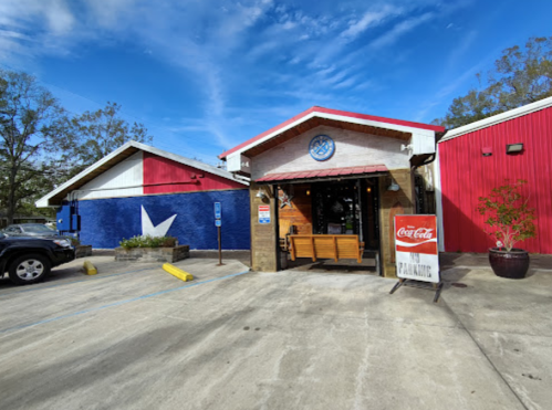 A colorful restaurant exterior featuring a blue wall with a white star and a red side, with a sign for parking.