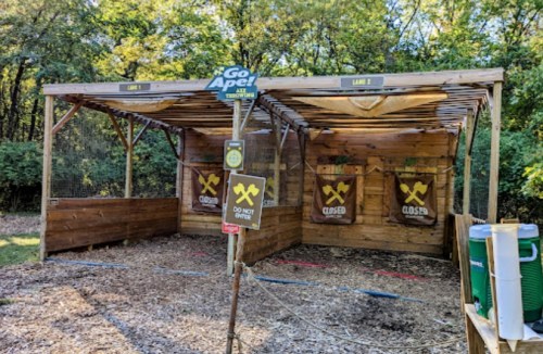A wooden structure with two closed target areas, surrounded by trees, and a sign indicating "Go Ape!" and "Do Not Enter."