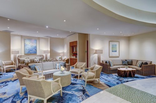 A modern lounge area with comfortable seating, soft lighting, and decorative artwork on the walls.