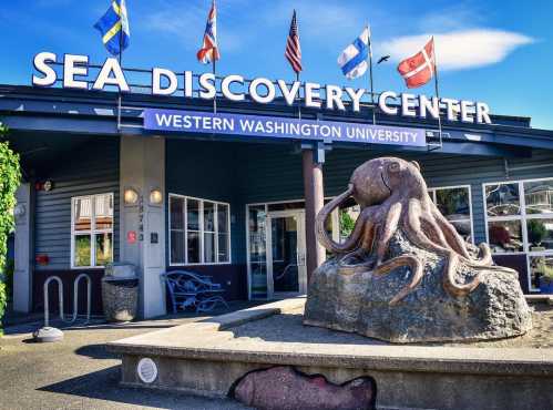 Entrance of the Sea Discovery Center at Western Washington University, featuring an octopus sculpture and flags.