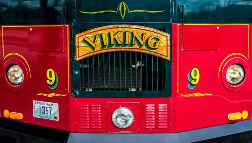 Close-up of a red and green trolley with "VIKING" sign and decorative elements, featuring headlights and a license plate.
