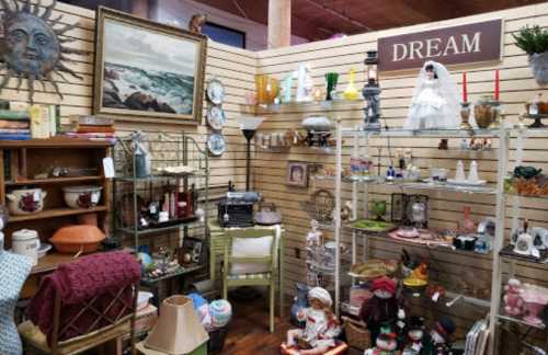 A cozy vintage shop display featuring various antiques, decor items, and a sign that says "DREAM."