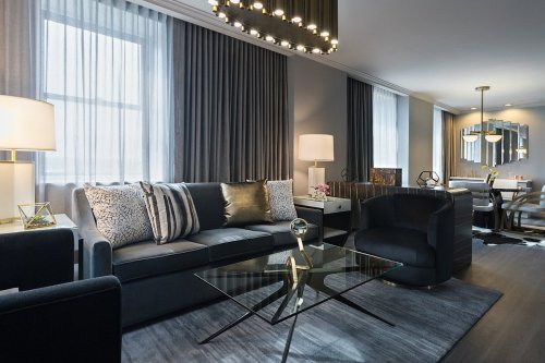 Modern living room featuring a sleek sofa, glass coffee table, stylish lighting, and elegant decor.