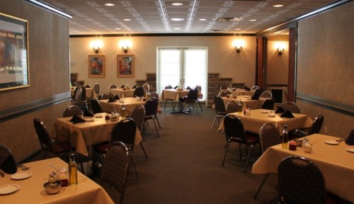 A spacious dining room with neatly set tables, soft lighting, and a cozy atmosphere.