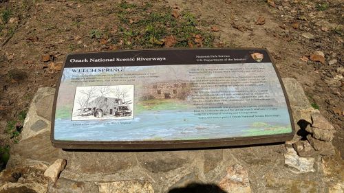 Sign at Ozark National Scenic Riverways detailing Welch Spring, featuring an illustration and historical information.