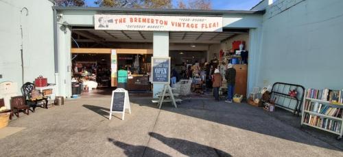 Entrance to the Bremerton Vintage Flea market, featuring various vintage items and shoppers browsing inside.