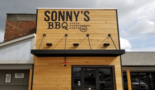 Exterior of Sonny's BBQ restaurant featuring a wooden facade and a sign with the establishment's name and founding year.