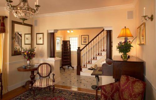 Cozy living room with elegant decor, a staircase, floral arrangements, and warm lighting.
