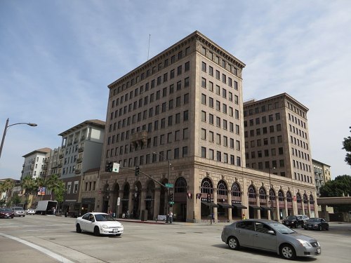 Historic multi-story building with a classic facade, located at a busy intersection with cars passing by.