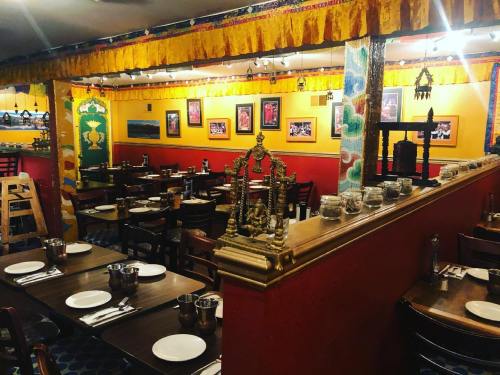 Cozy restaurant interior with colorful decor, wooden tables, and traditional artwork on the walls.
