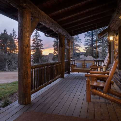 Cozy porch with wooden rocking chairs, overlooking a scenic sunset and pine trees.