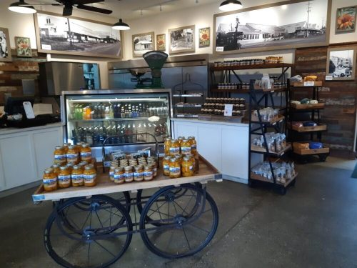 A rustic store interior featuring a display of jars, baked goods, and vintage decor on the walls.