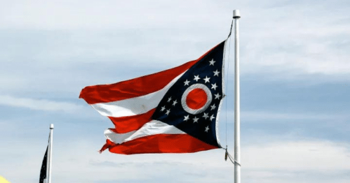 Ohio state flag waving against a cloudy sky.