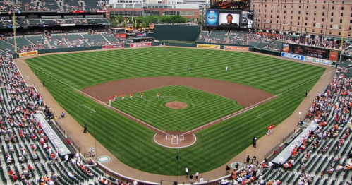 Aerial view of a baseball field with players on the diamond and a crowd in the stands.