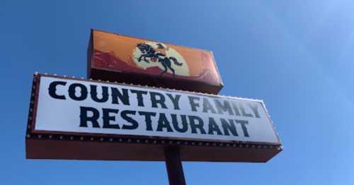 Sign for "Country Family Restaurant" with a cowboy on a horse against a blue sky.