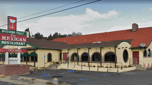 Exterior of Micasa Too Mexican Restaurant, featuring a colorful sign and arched windows, set against a clear sky.