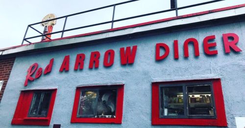 Exterior of the Red Arrow Diner, featuring bold red signage and large windows.