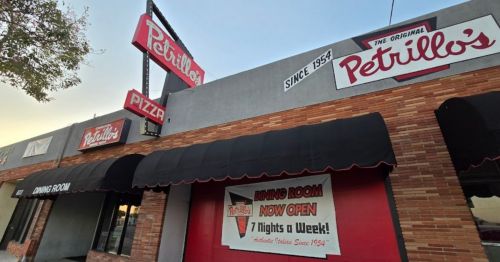 Exterior of Petrillo's Pizza, featuring a sign with the name and "Since 1954," and a banner announcing the dining room's opening.