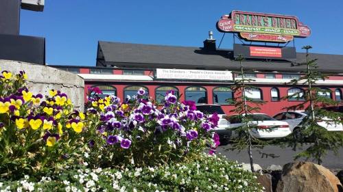 Colorful flowers in the foreground with Frank's Diner building and clear blue sky in the background.
