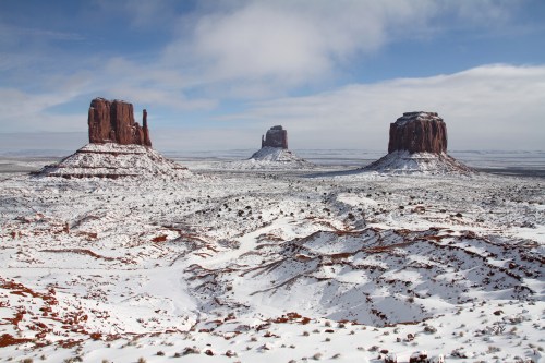 Snow-covered landscape featuring three iconic rock formations under a cloudy sky.