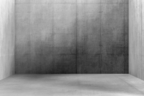 Empty room with smooth gray concrete walls and floor, creating a minimalist and industrial aesthetic.