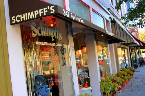 Storefront of Schimpff's Chocolates with autumn decorations and a sign displaying the address, 347 Spring St.