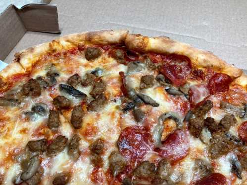 A close-up of a pepperoni and sausage pizza with melted cheese and mushrooms, in a pizza box.