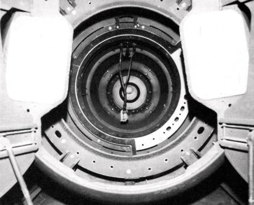 Close-up view of a circular mechanical structure with concentric rings and a central connector, set against a dark background.