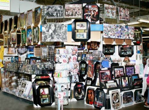 A vibrant display of framed photos and memorabilia in a market, featuring various celebrities and artistic pieces.