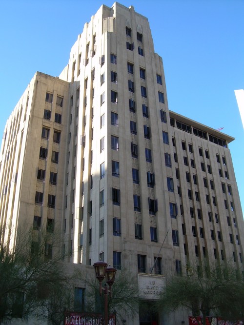 Historic multi-story building with a distinctive architectural style, featuring large windows and a clear blue sky.
