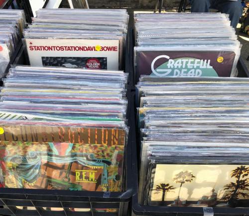 A collection of vinyl records displayed in bins, featuring artists like David Bowie and Grateful Dead.