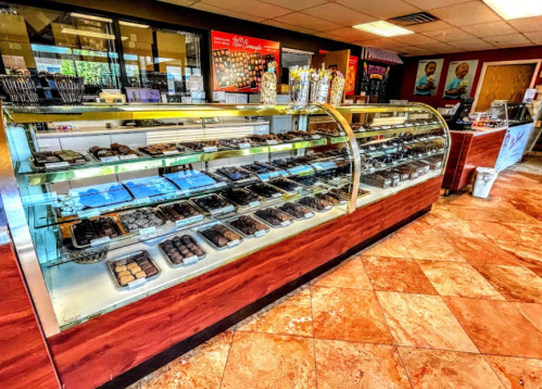A display case filled with various chocolates and confections in a bright, inviting shop interior.
