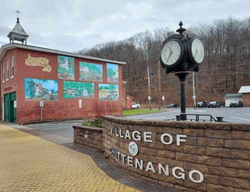 Historic Chittenango mural on a brick building with a vintage clock and sign marking the village entrance.