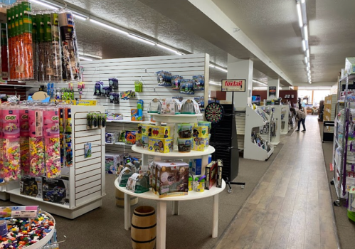 A colorful store aisle filled with toys and games, featuring shelves and displays on either side.