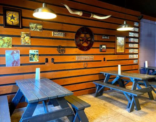 Rustic dining area with wooden tables, wall decor including photos and a star, and warm lighting.
