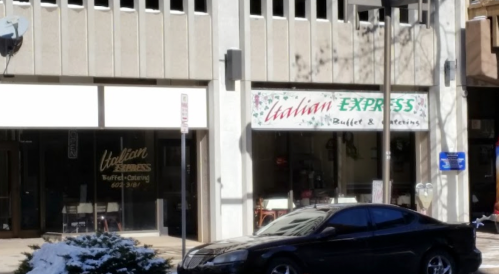 Exterior view of Italian Express, a buffet and catering restaurant, with a black car parked in front.