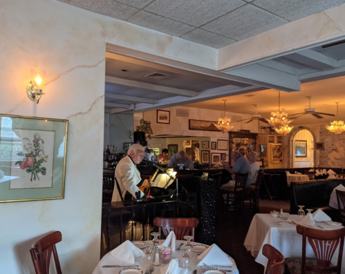 A cozy restaurant scene with a musician playing, elegant decor, and diners enjoying their meals in a warm atmosphere.