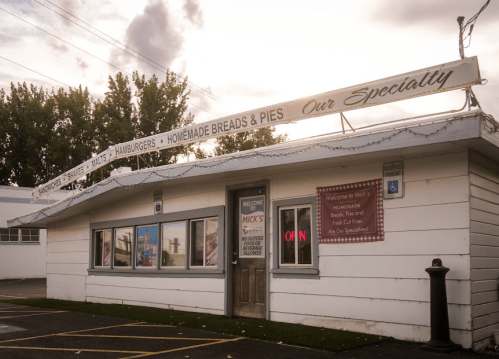A small, charming diner with a sign reading "Micky's" and "Homemade Breads & Pies" under a cloudy sky.