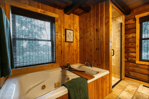 Cozy bathroom with a wooden interior, featuring a jetted tub, shower, and natural light from windows.
