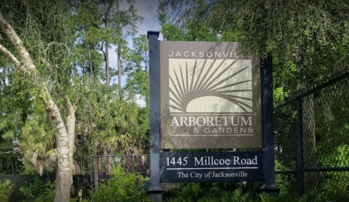 Sign for the Jacksonville Arboretum & Gardens, located at 1445 Millcoe Road, surrounded by greenery.
