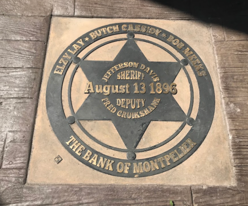 A star-shaped plaque commemorating Elzy Lay, Butch Cassidy, and Bob Mintz at the Bank of Montpelier, dated August 13, 1896.